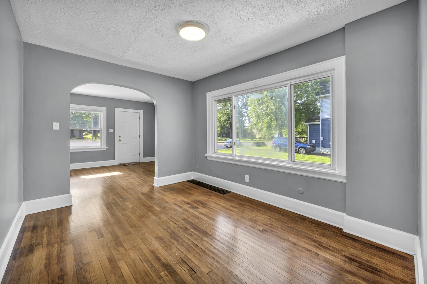Empty room with hardwood floors and an arched doorway