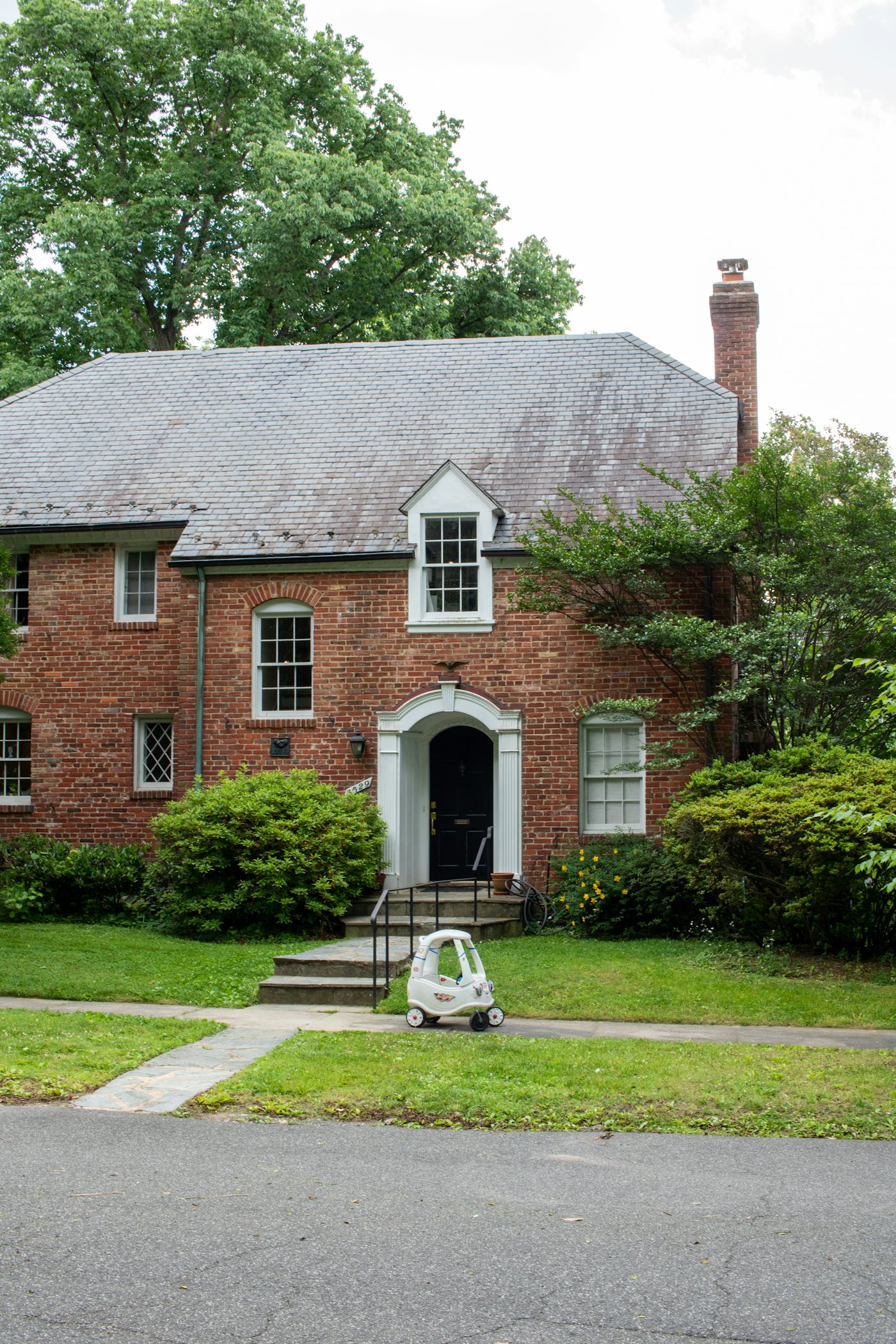 Brick two-story home with a front garden