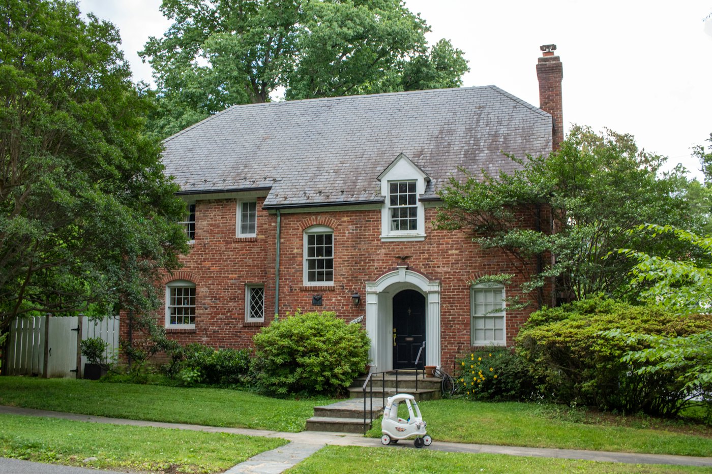 Two-story brick colonial home with a front walk