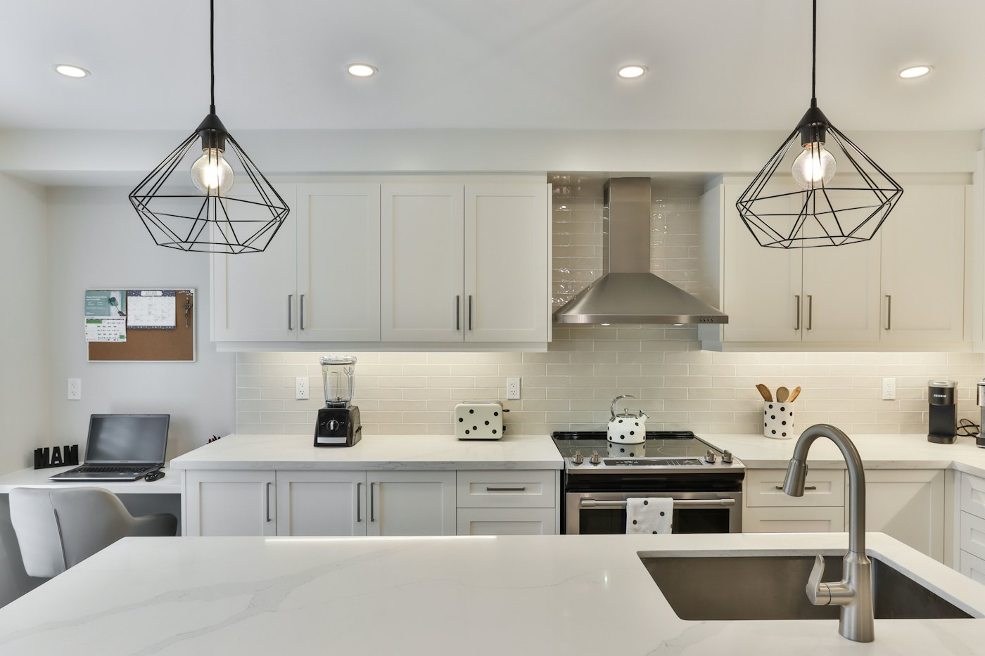 White kitchen with an island and pendant lights