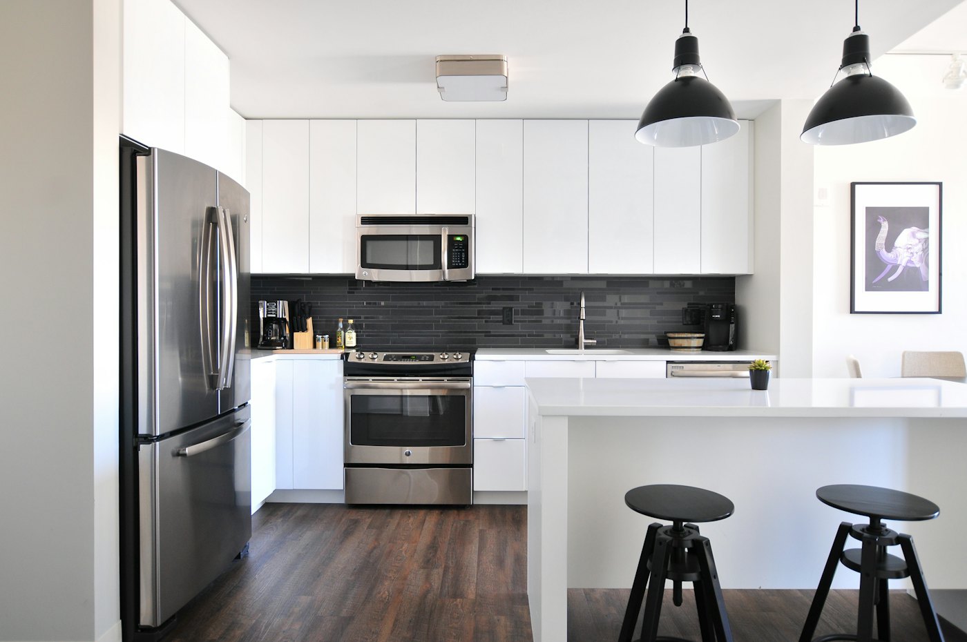 Clean kitchen with white cabinets and stainless appliances