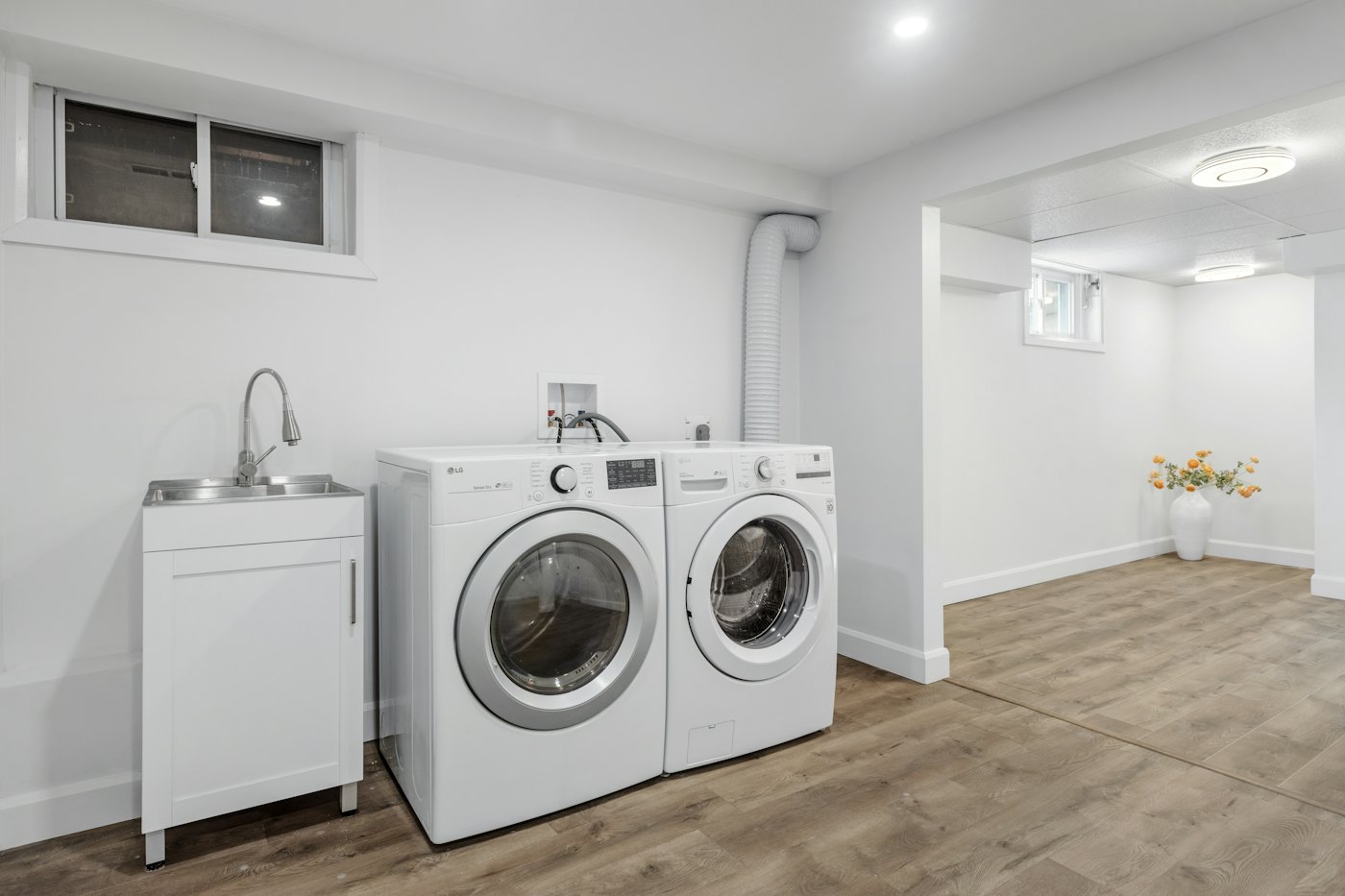 Basement laundry room with washer, dryer and utility sink