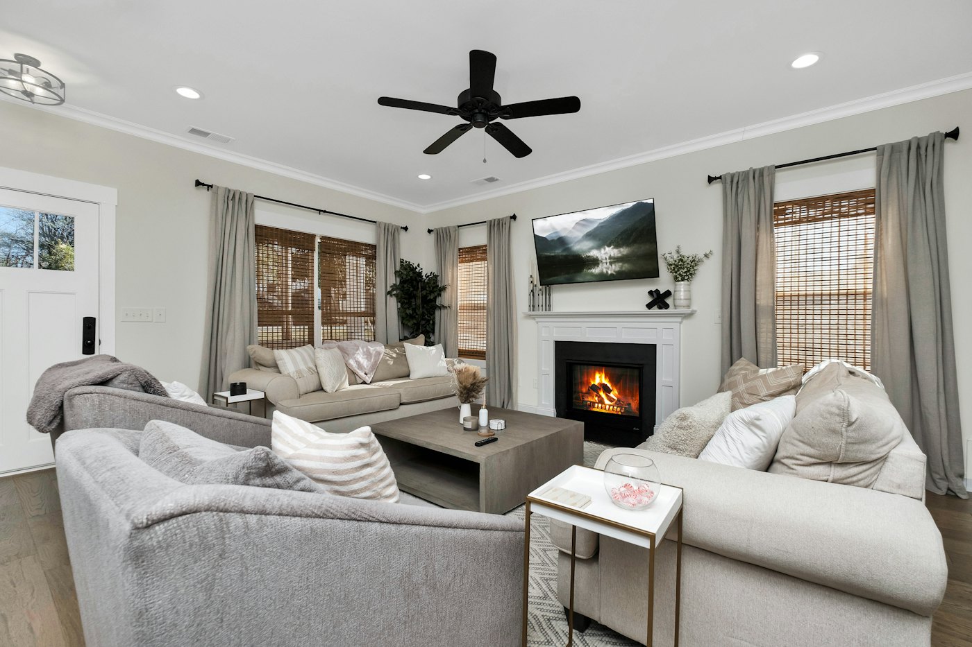 Living room with a ceiling fan, fireplace and gray sofas