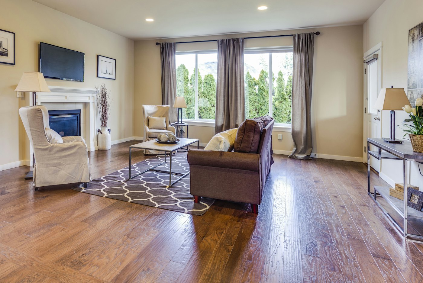 Living room with hardwood floors, a fireplace and front windows